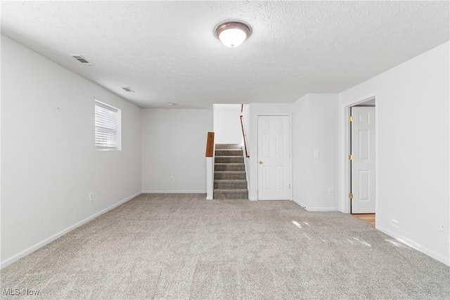 empty room featuring light colored carpet and a textured ceiling