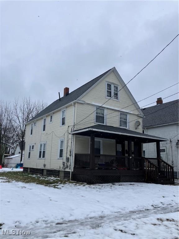 snow covered property featuring a porch