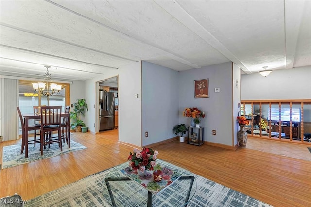 living room with hardwood / wood-style floors, a textured ceiling, and a chandelier