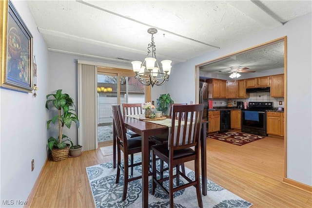 dining area with ceiling fan with notable chandelier, a textured ceiling, and light wood-type flooring