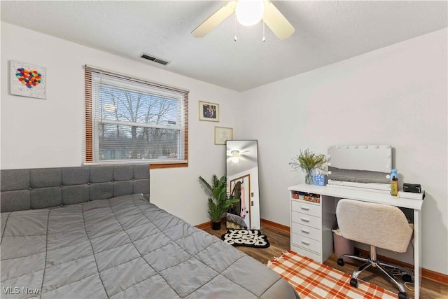 bedroom with hardwood / wood-style floors, a textured ceiling, and ceiling fan