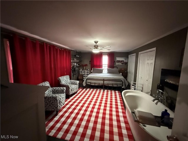 bedroom featuring crown molding, ceiling fan, and two closets