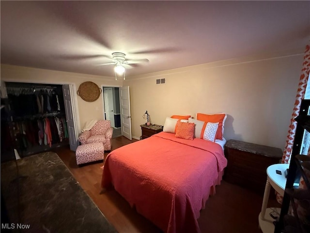 bedroom featuring ceiling fan, dark hardwood / wood-style floors, and a closet