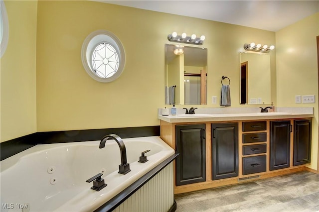 bathroom with vanity, hardwood / wood-style flooring, and a tub