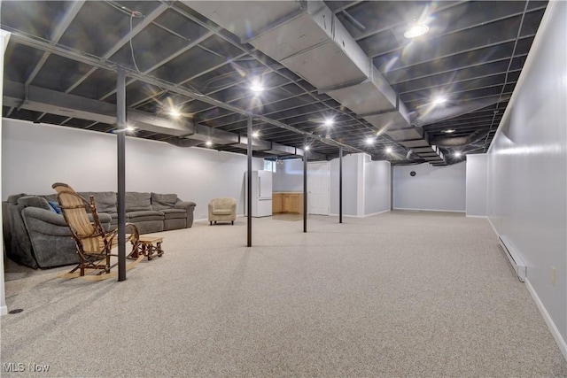 basement with carpet floors, a baseboard radiator, and white refrigerator