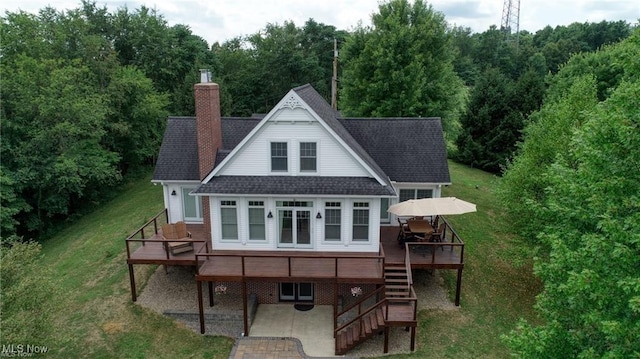 back of property featuring a wooden deck, a patio, and a lawn