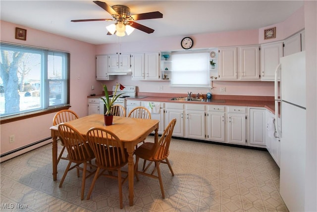 dining area with sink, ceiling fan, and a baseboard heating unit