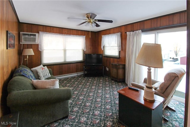 carpeted living room featuring plenty of natural light, wood walls, and baseboard heating