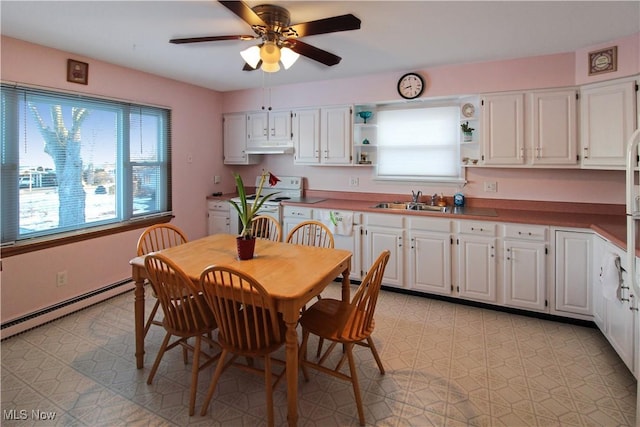 kitchen with a baseboard heating unit, white electric range, sink, and white cabinets