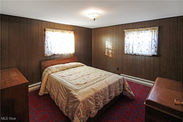 bedroom with a baseboard heating unit and wood walls