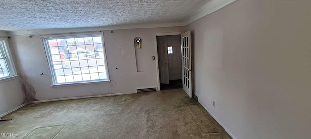 carpeted empty room with a textured ceiling