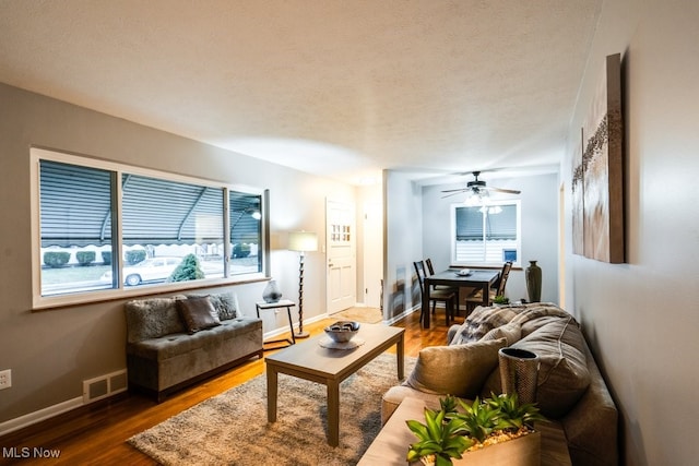 living room with dark hardwood / wood-style flooring and ceiling fan