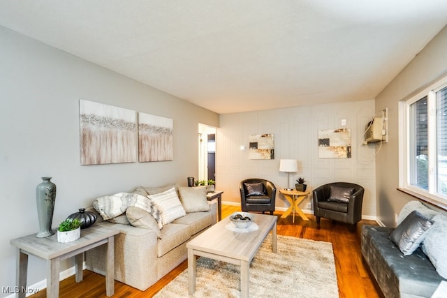 living room with dark hardwood / wood-style floors and a wall mounted air conditioner