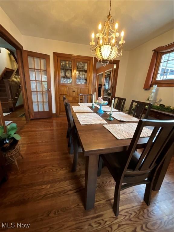 dining room with dark wood-type flooring and a chandelier