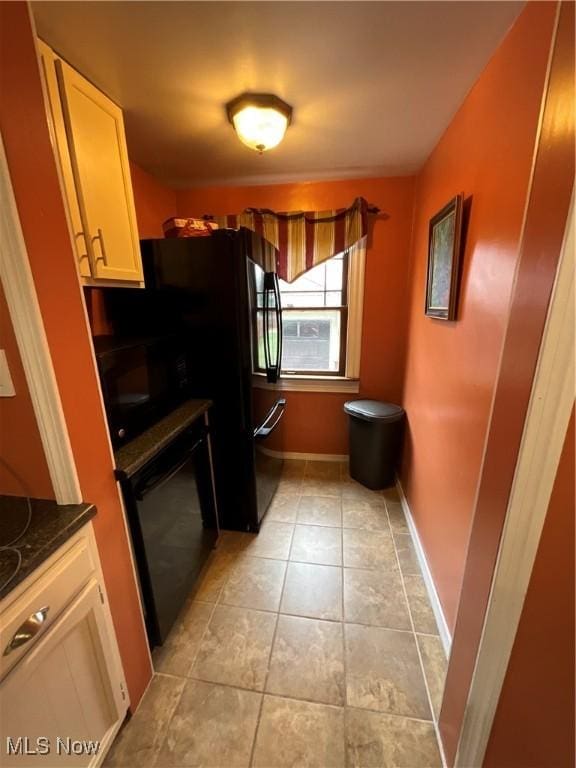 kitchen featuring black appliances and light tile patterned flooring