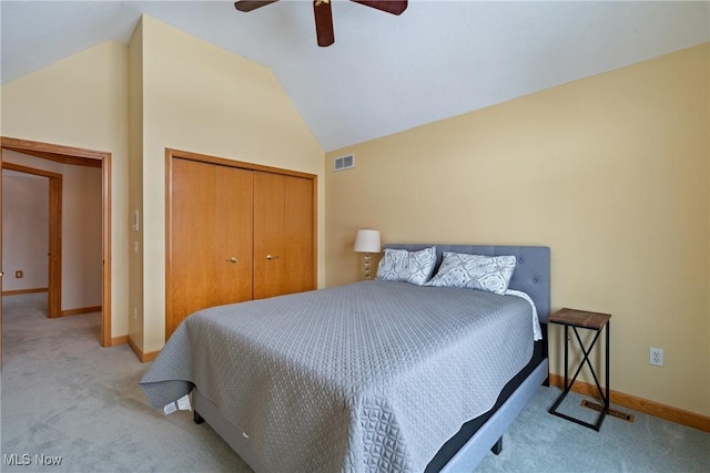 bedroom featuring lofted ceiling, light colored carpet, a closet, and ceiling fan