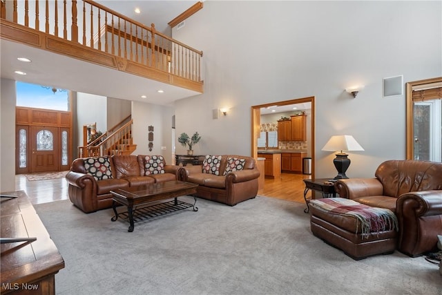 carpeted living room with a towering ceiling