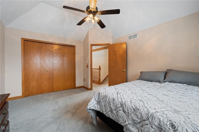 carpeted bedroom featuring ceiling fan, vaulted ceiling, and a closet