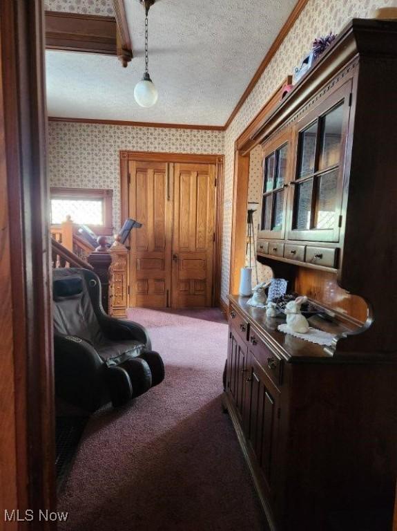 sitting room featuring crown molding, a textured ceiling, and carpet flooring