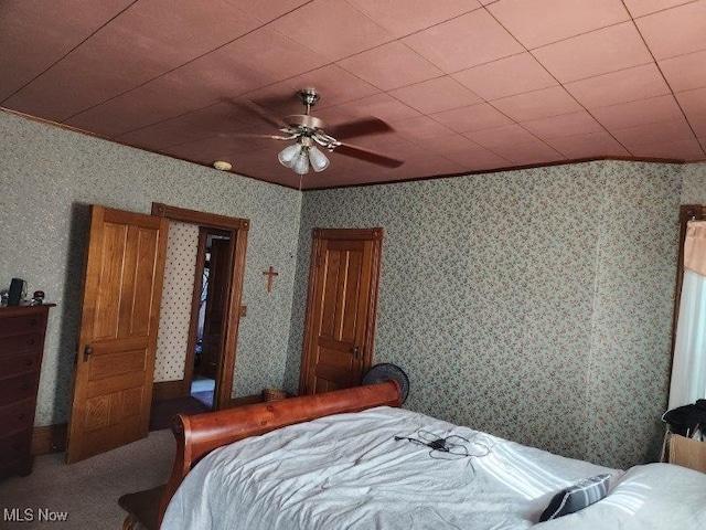 carpeted bedroom featuring ornamental molding and ceiling fan