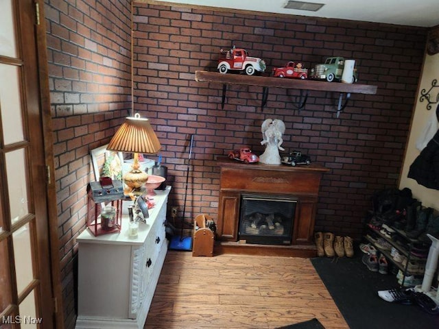 interior space featuring brick wall and light hardwood / wood-style floors