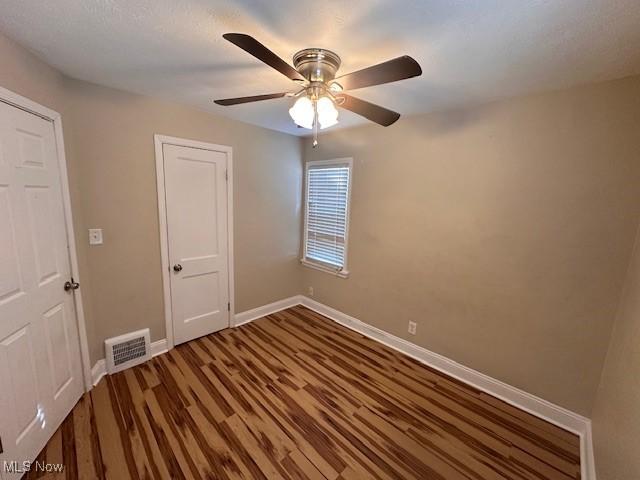 unfurnished room with wood-type flooring and ceiling fan