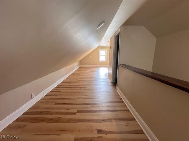 bonus room with lofted ceiling and light hardwood / wood-style flooring