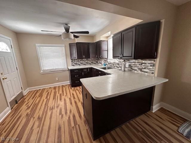 kitchen with tasteful backsplash, plenty of natural light, sink, and kitchen peninsula