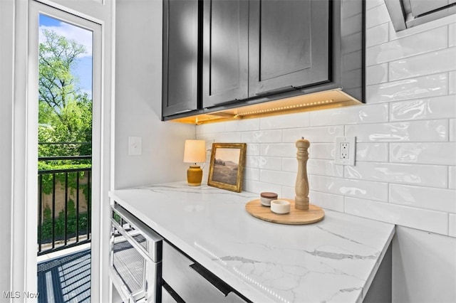 kitchen featuring light stone counters and tasteful backsplash