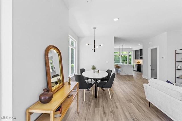 dining area with an inviting chandelier and light hardwood / wood-style flooring