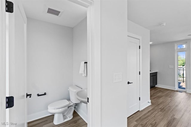 bathroom with hardwood / wood-style flooring and toilet