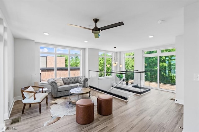 living room with light hardwood / wood-style flooring and ceiling fan