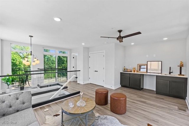 living room featuring light hardwood / wood-style floors, sink, and a notable chandelier