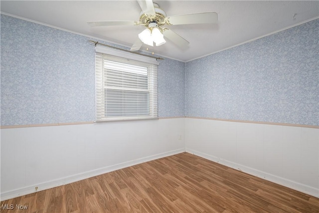 empty room with ornamental molding, wood-type flooring, and ceiling fan