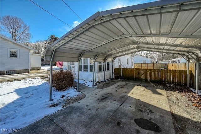 snow covered parking featuring a carport