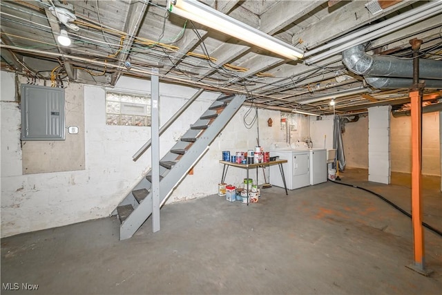 basement with washing machine and clothes dryer and electric panel