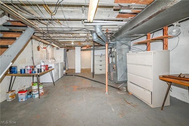 basement featuring washing machine and clothes dryer and heating unit