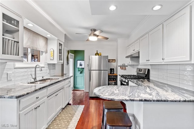 kitchen with white cabinetry, appliances with stainless steel finishes, sink, and light stone counters