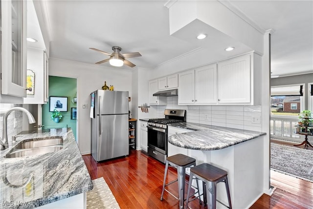 kitchen featuring sink, crown molding, stainless steel appliances, light stone counters, and white cabinets