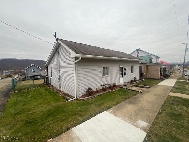 view of side of home with a yard