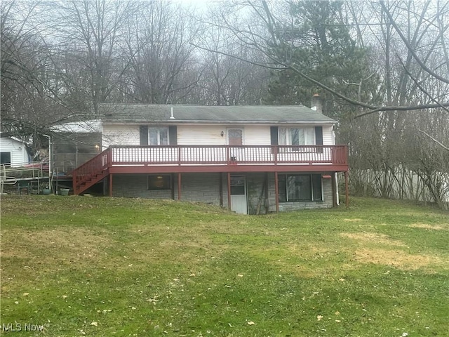 rear view of property featuring a yard and a deck