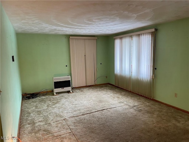 unfurnished bedroom featuring carpet floors and heating unit