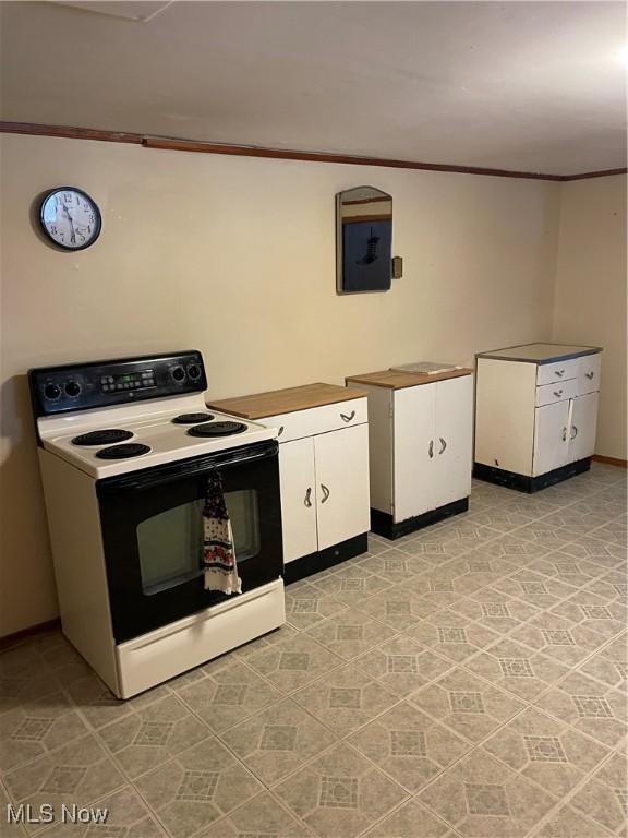 kitchen featuring range with electric cooktop, white cabinetry, and crown molding