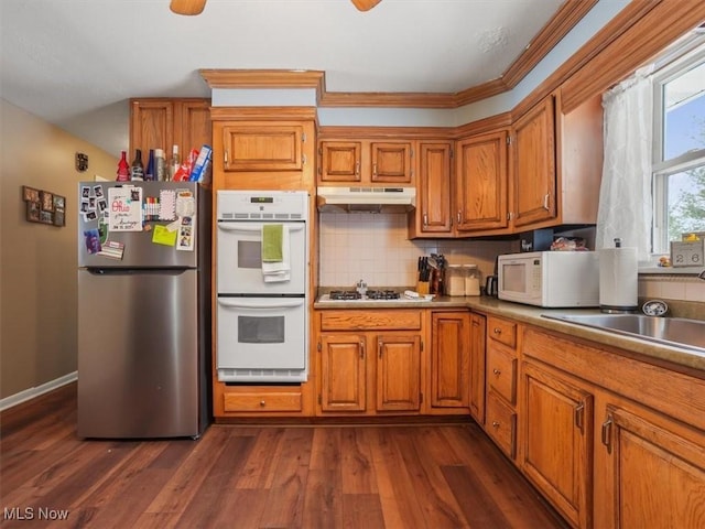 kitchen with tasteful backsplash, dark hardwood / wood-style flooring, sink, and white appliances