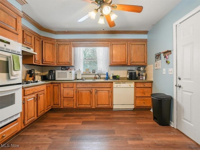 kitchen with dark hardwood / wood-style floors, sink, decorative backsplash, ceiling fan, and white appliances