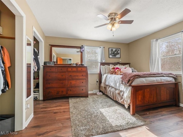 bedroom with multiple windows, hardwood / wood-style floors, and ceiling fan