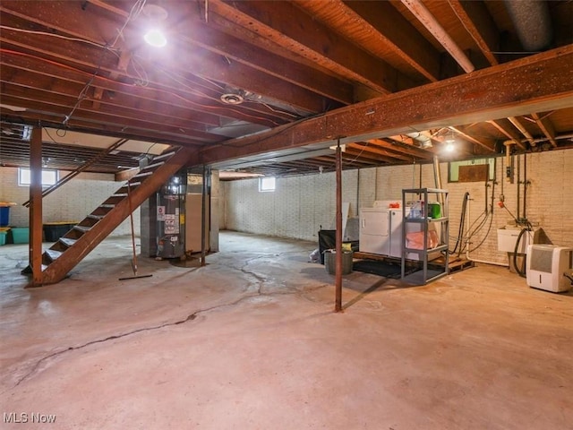 basement with water heater and independent washer and dryer