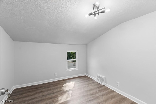 spare room featuring hardwood / wood-style flooring and a textured ceiling