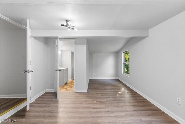 unfurnished bedroom featuring lofted ceiling and hardwood / wood-style floors