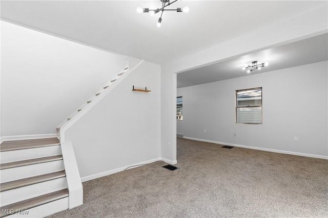 stairs with carpet floors and a notable chandelier